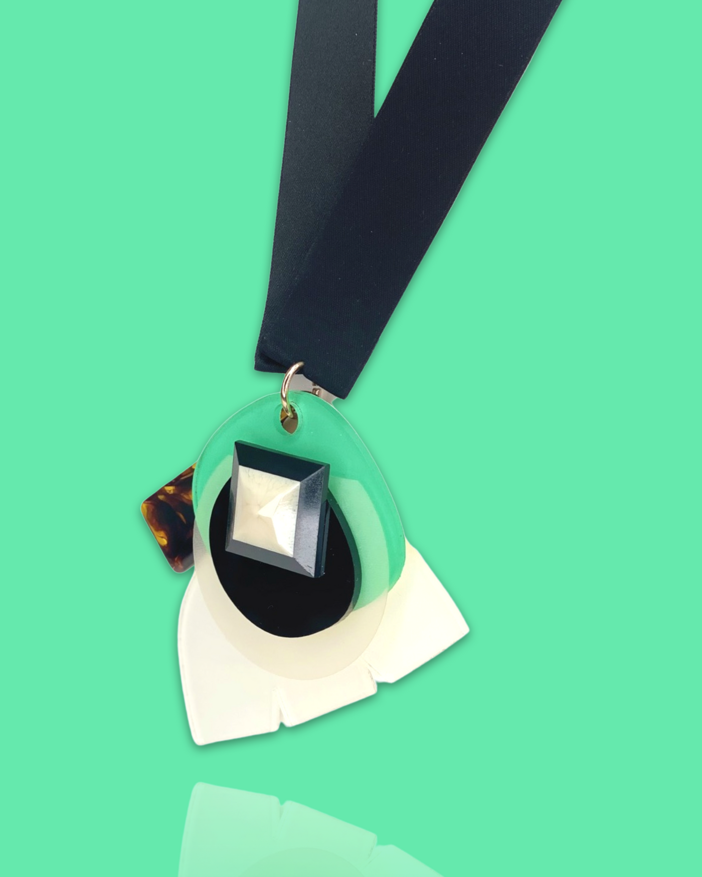 Stylish fashion necklace in seafoam color with acrylic hardware and silk ribbon fastening.