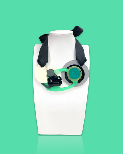 Artistic bold fashion necklace in seafoam color with geometric pendant and black silk ribbon fastening.