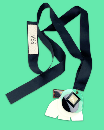 Stylish fashion necklace in seafoam color with acrylic hardware and silk ribbon fastening.