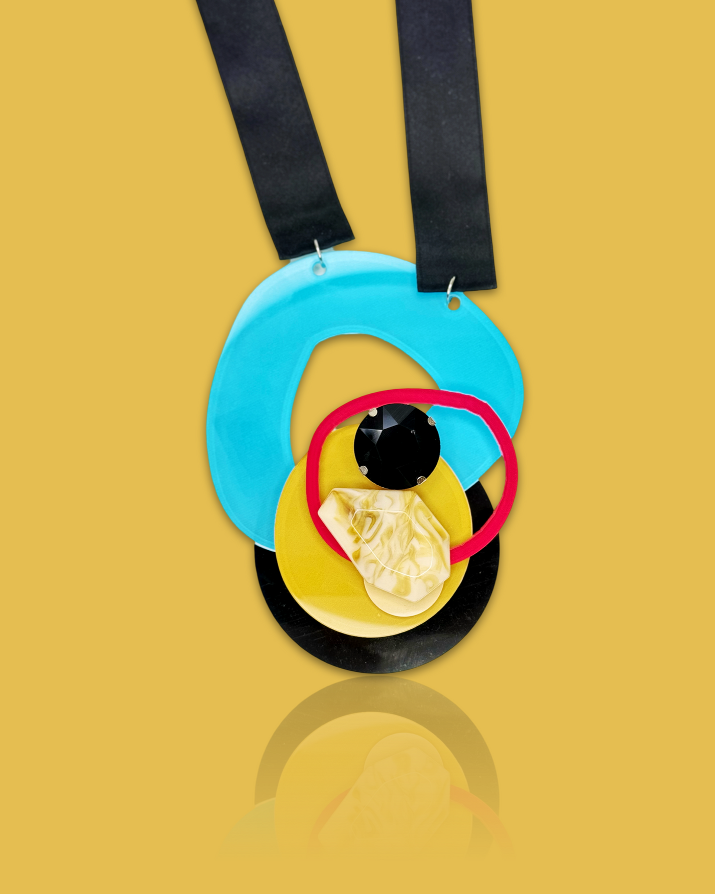 Bold fashion necklace brooch with irregular die-cut acrylic, sequins, and plastic gem on black silk ribbon.