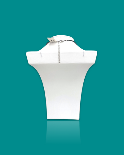Subtle trendy small pendant necklace with ocean-colored acrylic and leather cord on display stand.