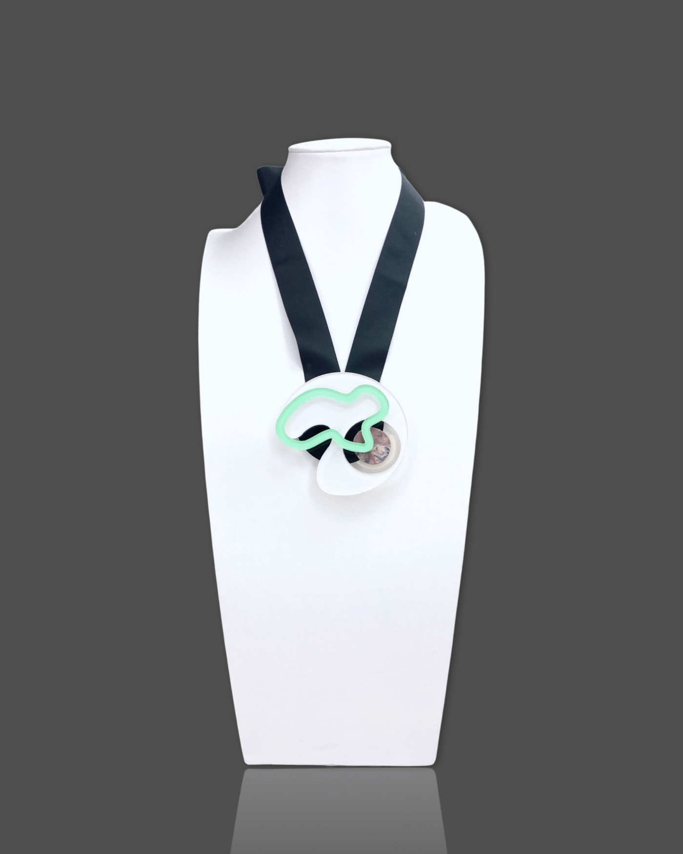 Geometric shapes necklace brooch in white with black ribbon, featuring irregular acrylic and marble pattern elements.