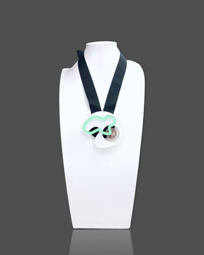 Geometric shapes necklace brooch in white with black ribbon, featuring irregular acrylic and marble pattern elements.