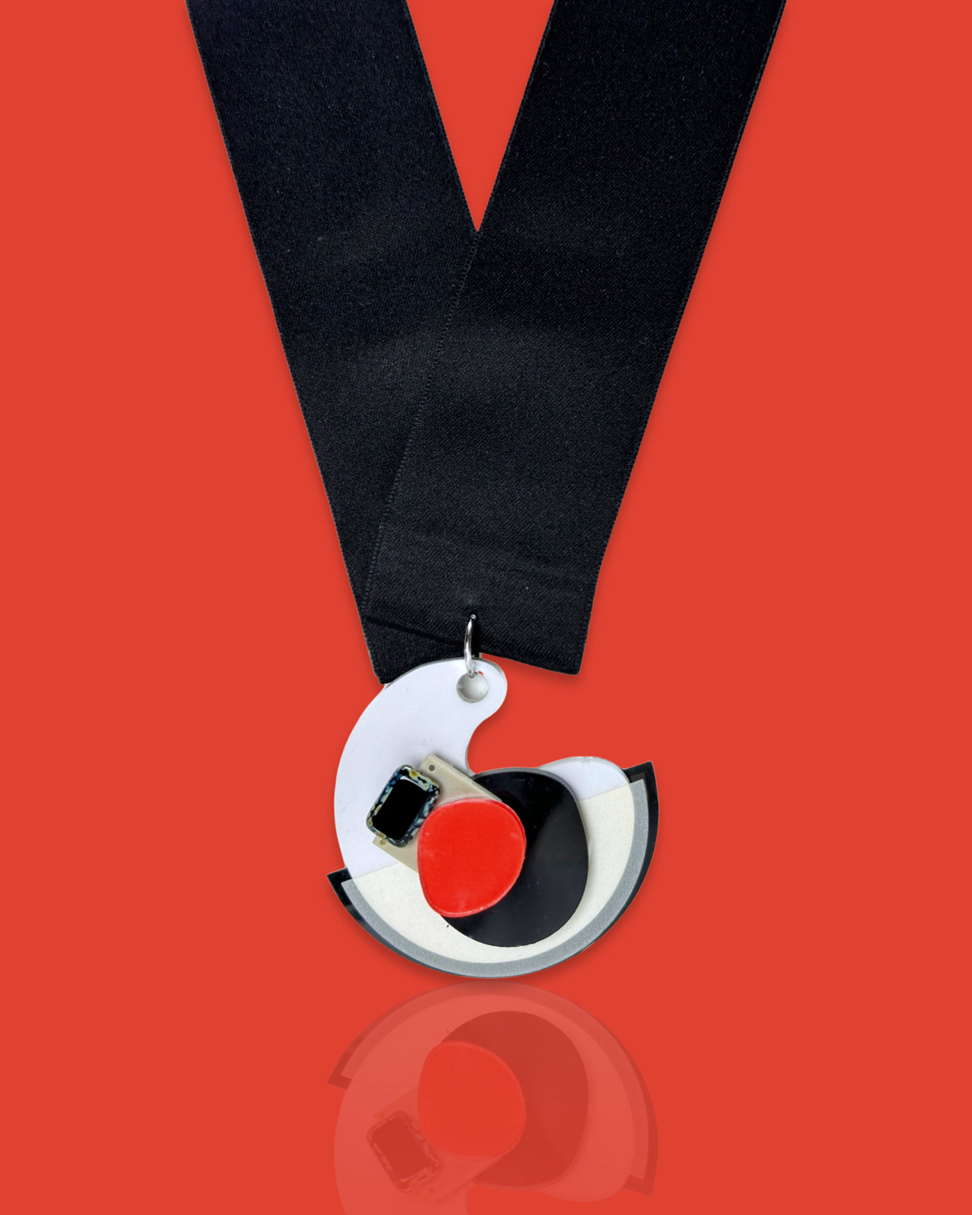 Minimal blob-shaped long necklace with a small white and red pendant, featuring an acrylic design and silk ribbon fastening.