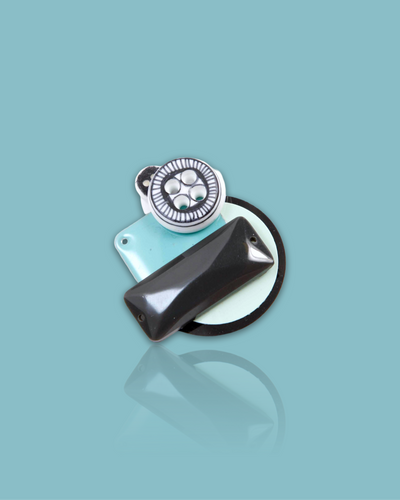 Turquoise color small brooch with hand-drawn button design.