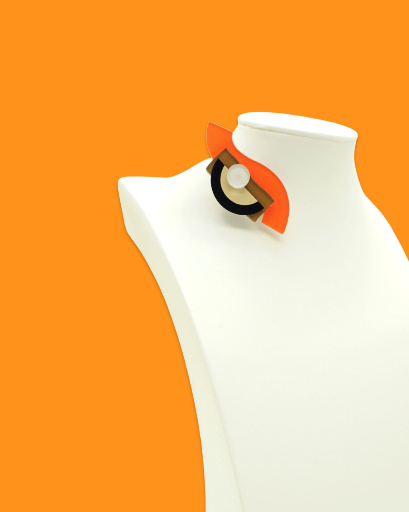 Small geometric-shaped tiger color brooch with playful design on display mannequin.