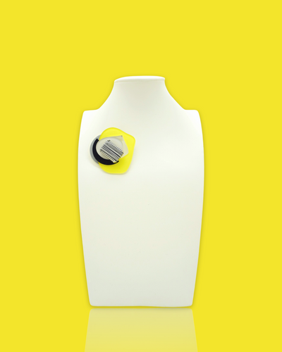 Avant-Garde brooch with striped lemon-colored bead on display.