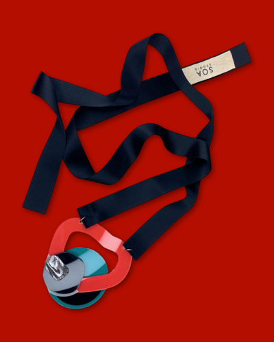 Geometric shape necklace in red with irregular acrylic design, marble-patterned clay, black sequin, and silk ribbon fastening.